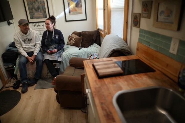 Artists Scott Donovan, left, and Tiffany Bailey, right, sit inside Bailey's home at Goodness Village on Tuesday, Oct. 31, 2023, in Livermore, Calif. Goodness Village provides the Tri-Valley's formerly unhoused neighbors a safe and supportive community to live independently. Since living at the village for the past two years Bailey and Donovan have started a small business named Fresh Start Art. (Aric Crabb/Bay Area News Group)