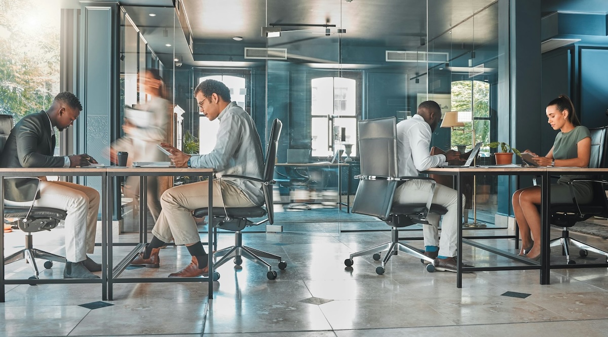 A group of people sitting at desks in an office.