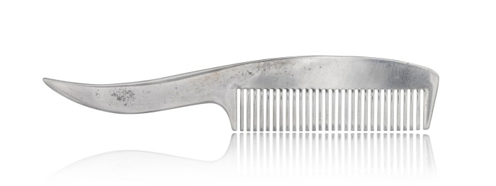 A small silver comb with a handle that curves and tapers to a tip