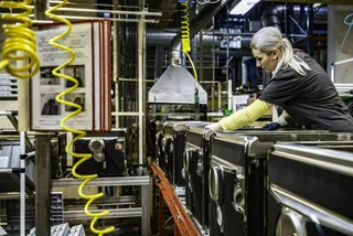 Woman working at an assembly line. Photo: iStock / vm