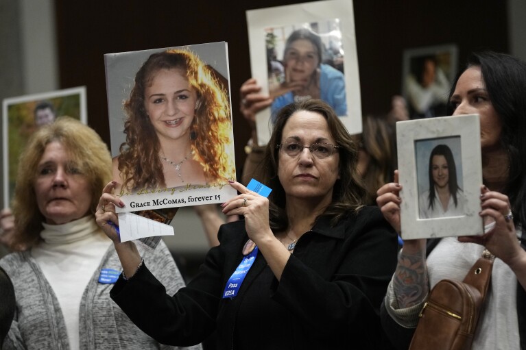 People hold photos of their loved ones as they sit in the audience before the start of a Senate Judiciary Committee hearing with the heads of social media platforms on Capitol Hill in Washington, Wednesday, Jan. 31, 2024, to discuss child safety. (AP Photo/Susan Walsh)