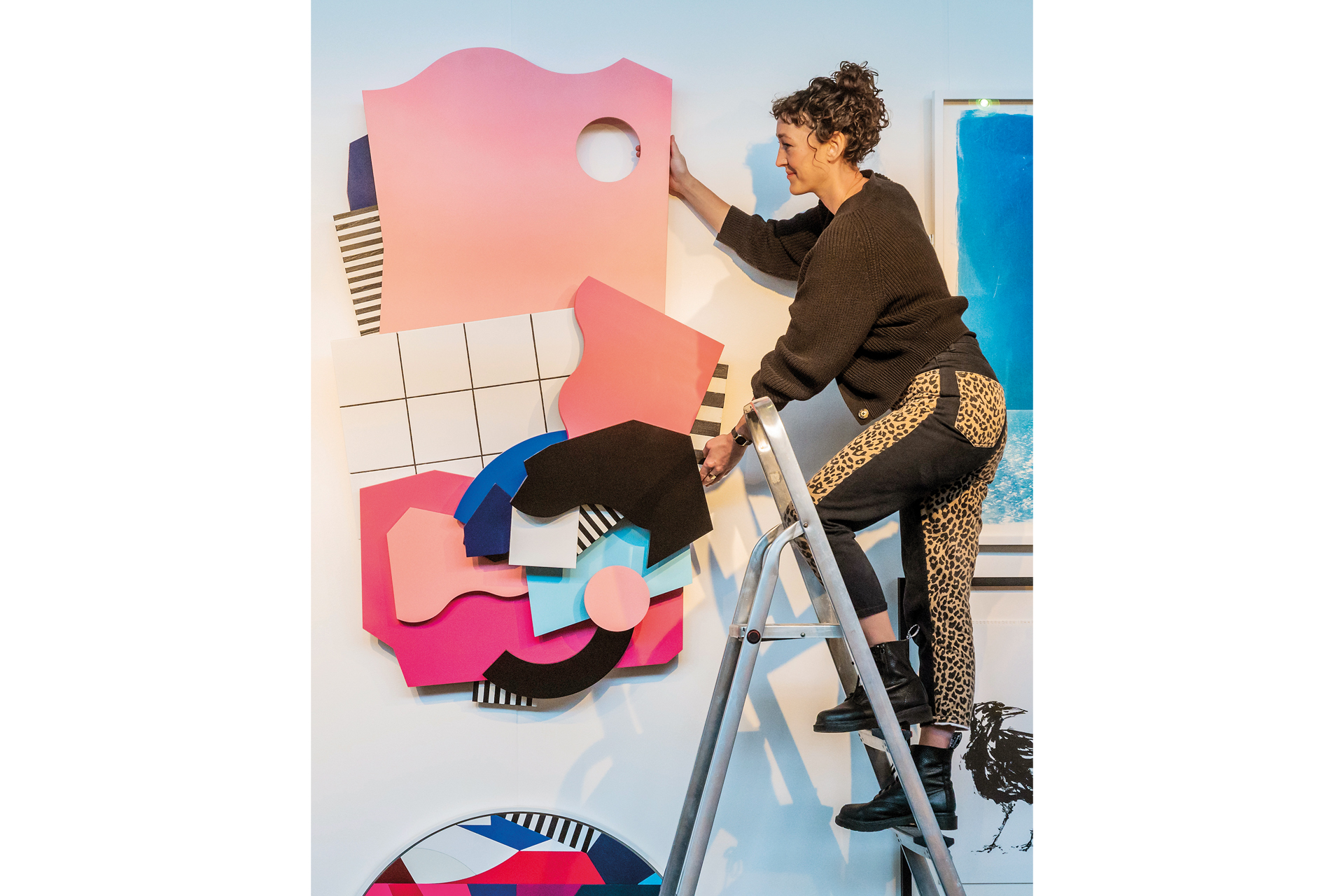 A gallerist adjusts work at Affordable Art Fair Battersea. Photo by Guy Bell