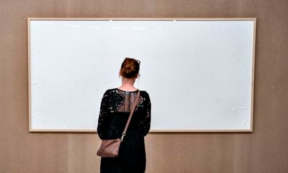 A woman looks at the painting 'Take the Money and Run,' by Jens Haaning, at the Kunsten Museum in Aalborg, Denmark.