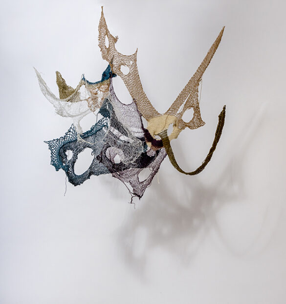 Photo of a sculpture of a net hanging against a wall