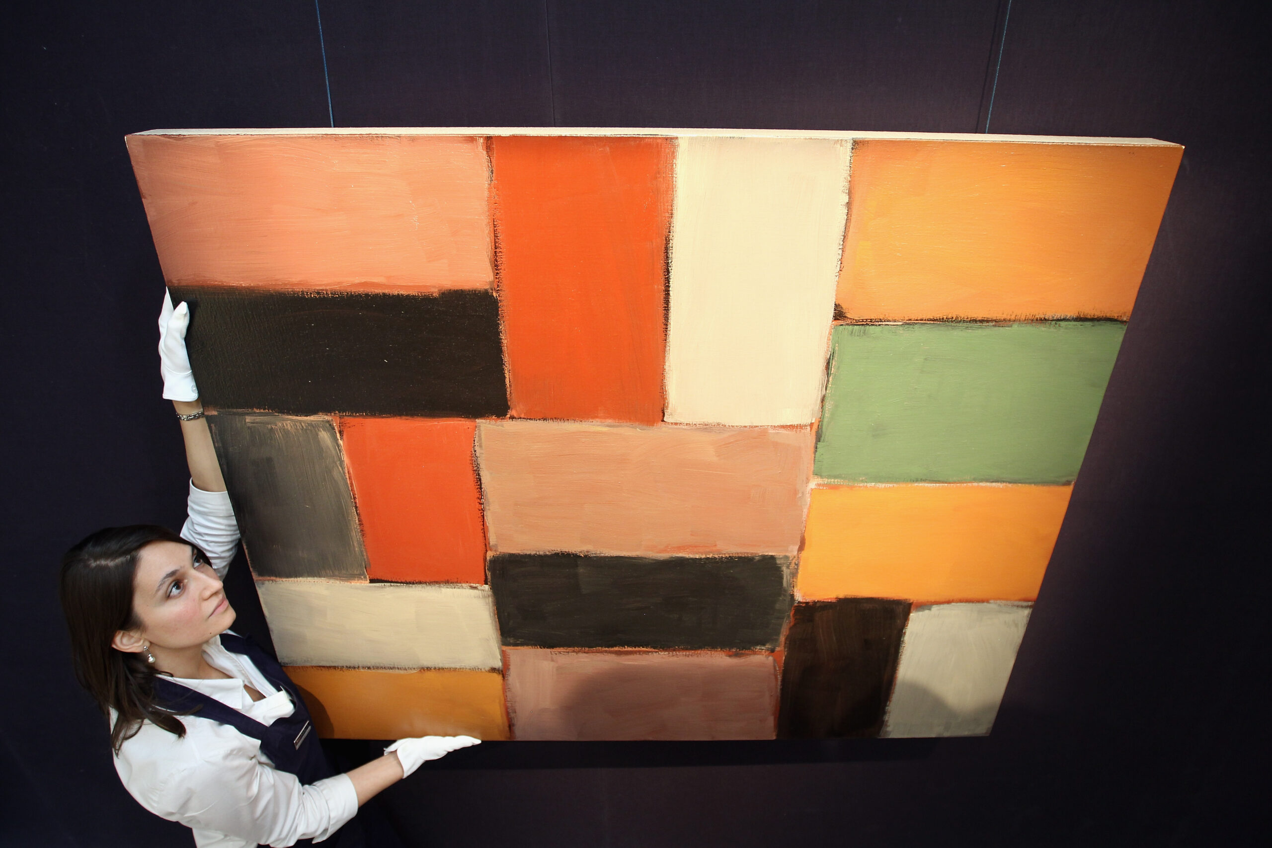 A Sotheby's hangs 'Wall of Light Orange Green' by Sean Scully in preparation for a November 3, 2010 sale.