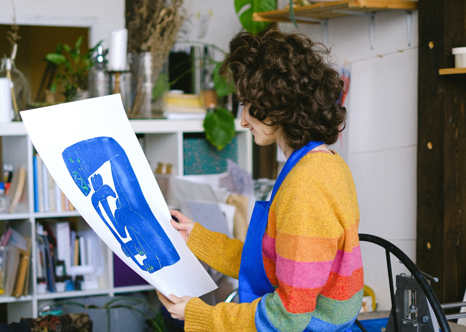 An artist examines a painting in her own studio