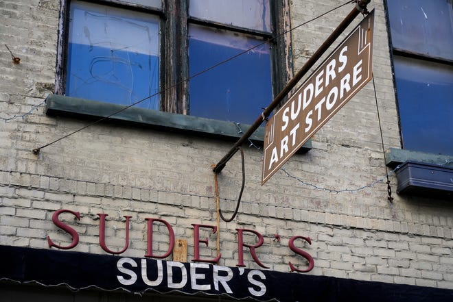 Different styles of signs hang outside Suder’s Art Store’s storefront on Tuesday, Jan. 16, 2024, at Suder’s Art Store in Over-the-Rhine.