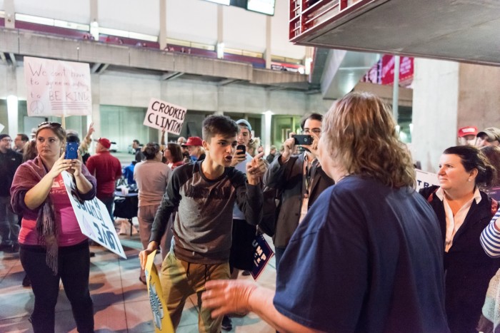 People use their phones to film a heated argument between Trump and Clinton supporters in the 2016 US election