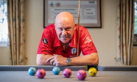 Neil Jones leaning on a snooker table, holding a cue.