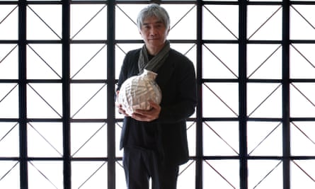 Hurozi Suzuki holding a pice of his work 