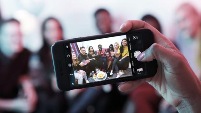 Taking photo of young people at house party