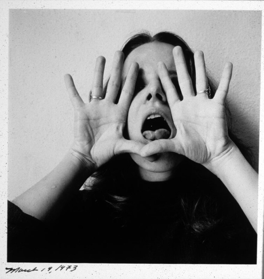 Melissa Shook self-portrait photograph, holding her hands to her face, palms out, and sticking out her tongue. 