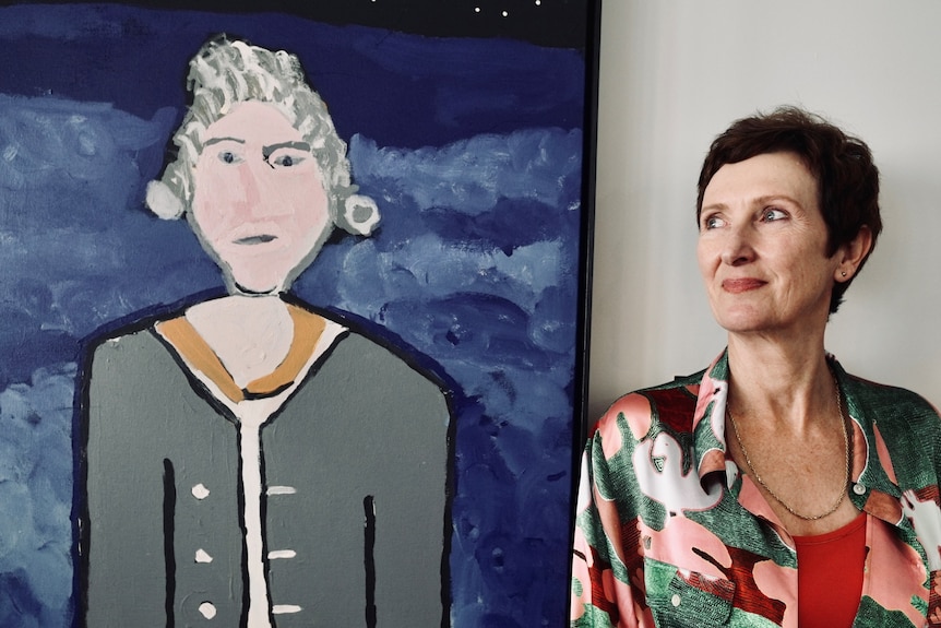 The Copyright Agency's head of visual arts Judy Grady stands next to a painting.