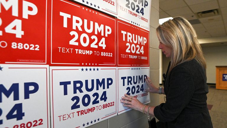 A person places posters of the campaign of former U.S. President and Republican presidential candidate Donald Trump, in Newton, Iowa, U.S., January 6, 2024. Pic: Reuters/Sergio Flores