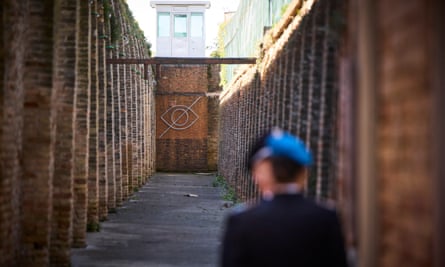 Artwork of a large eye with a line through it installed below a prison lookout tower