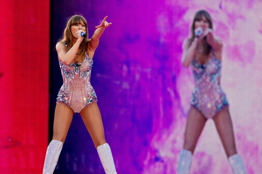 Taylor Swift leaning and pointing