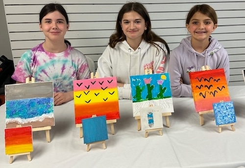 Three girls with paintings