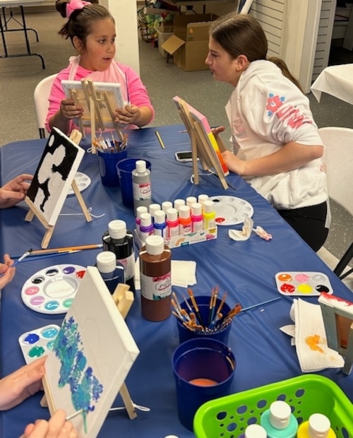 Two girls working on paintings