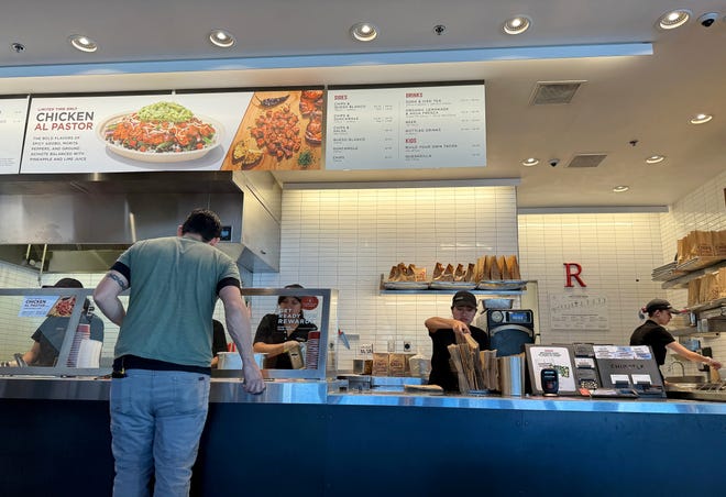 Workers help a customer at a Chipotle restaurant on April 1, 2024 in San Rafael, California.