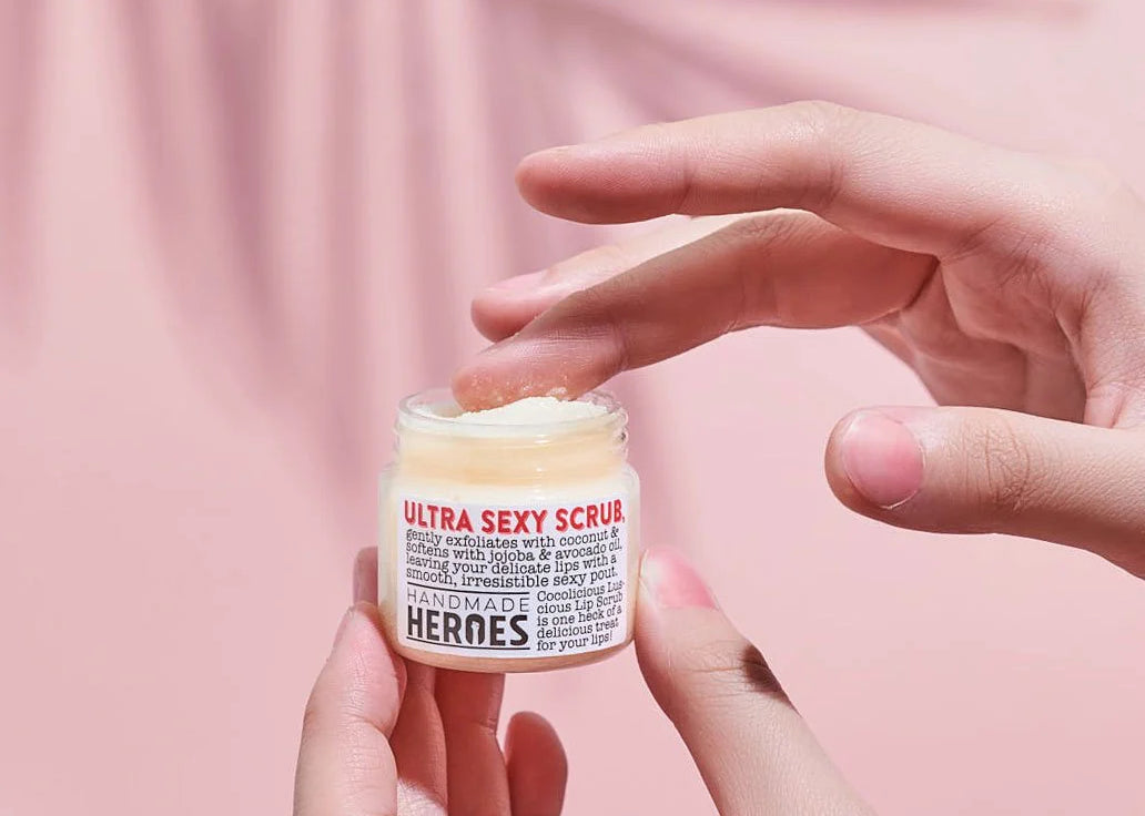 A close up of a hand holding a lip balm tub