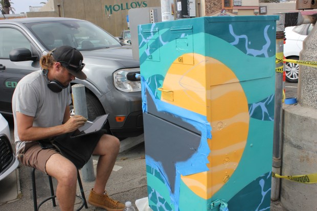Artist Josh Barnes is pictured on May 30 putting the...