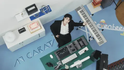 Pledis Entertainment Woozi - promotional image, showing him at his music station