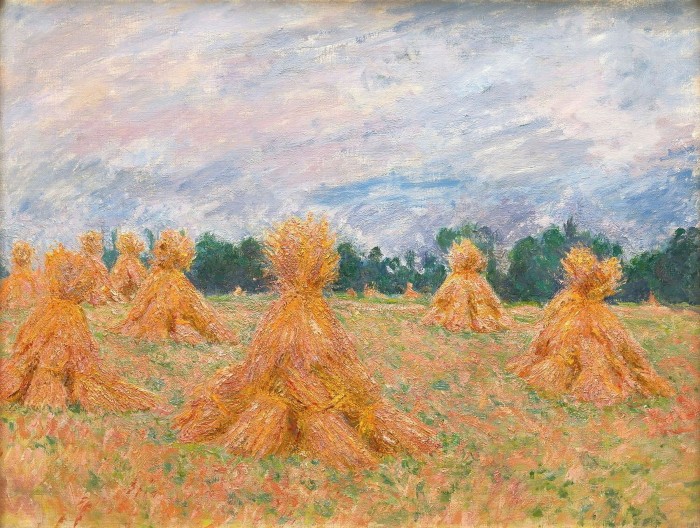 In a painting, dozens of golden haystacks dot an autumnal field standing out against the dark green wood and pink-shaded clouds visible in the background.