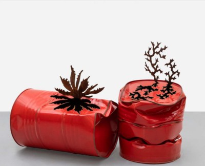 Two red barrels, both of which have been smashed in parts. Plant-like forms are cut out of their sides and bent to stand upright.