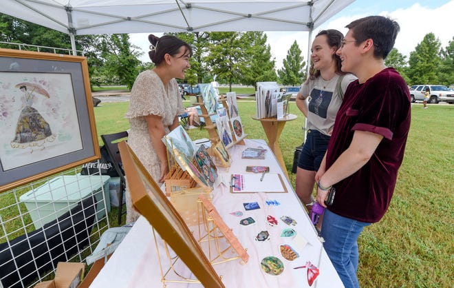 Abi Brewer shows her art to Catherine Doherty and Lyn Coupland Lewery at the Kentuck Art Market Saturday on the grounds of Kentuck’s new location on Jack Warner Parkway in Tuscaloosa.