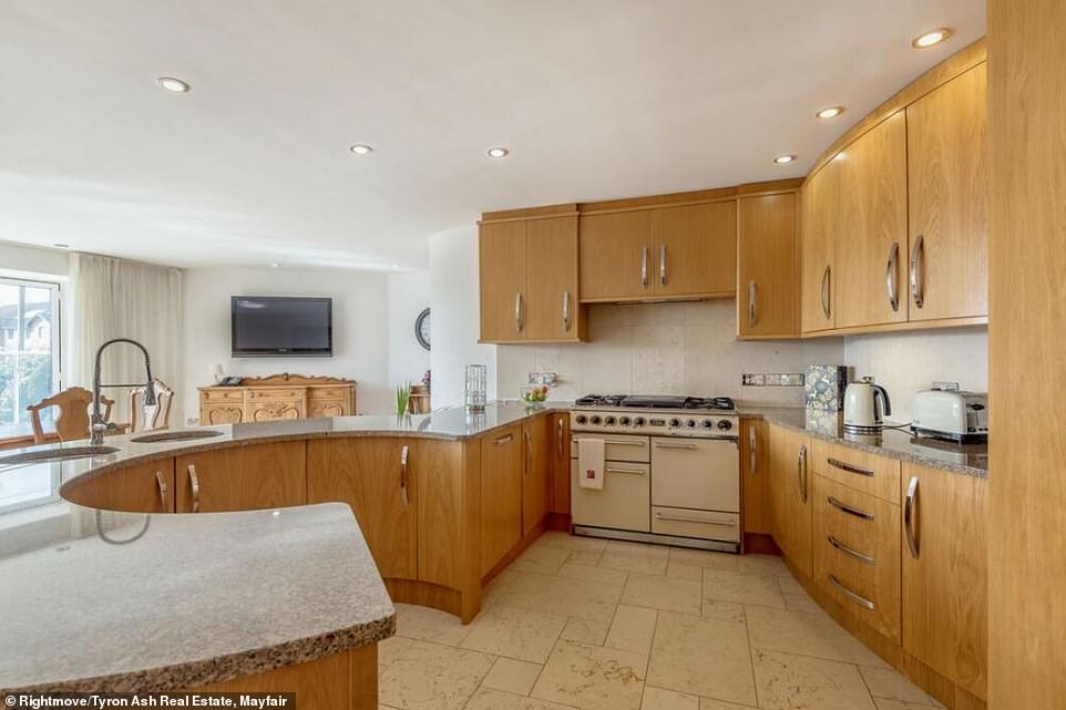 The kitchen has a large horseshoe-shaped countertop and is complete with a stylish designer oven