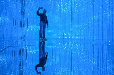 A visitor takes a selfie at an exhibition after a media tour of the new location for the digital art of Japanese collective 