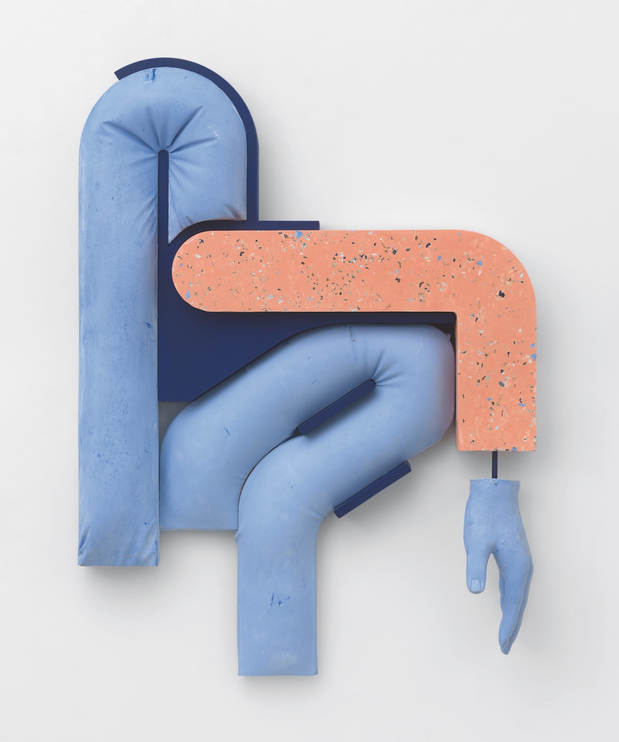 an abstract wall sculpture by Holly Hendry featuring blue and peach curbed shapes with a cast of a hand suspended off the end of the right side