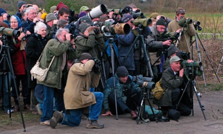 A crowd of people with tripods and long lens cameras 