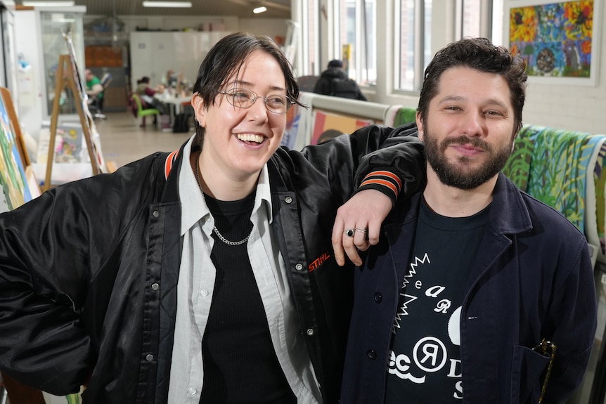 A woman and a man stand next to each other and smile. 