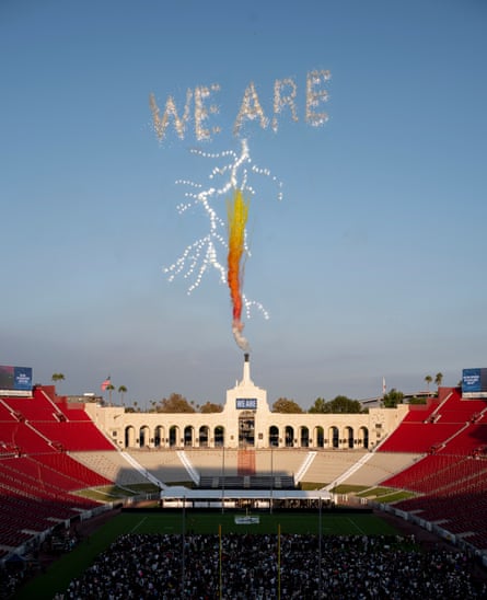 A plume of orange and red smoke emerges from the sky as a lighting bolt and the words “We are” are depicted through a fireworks display