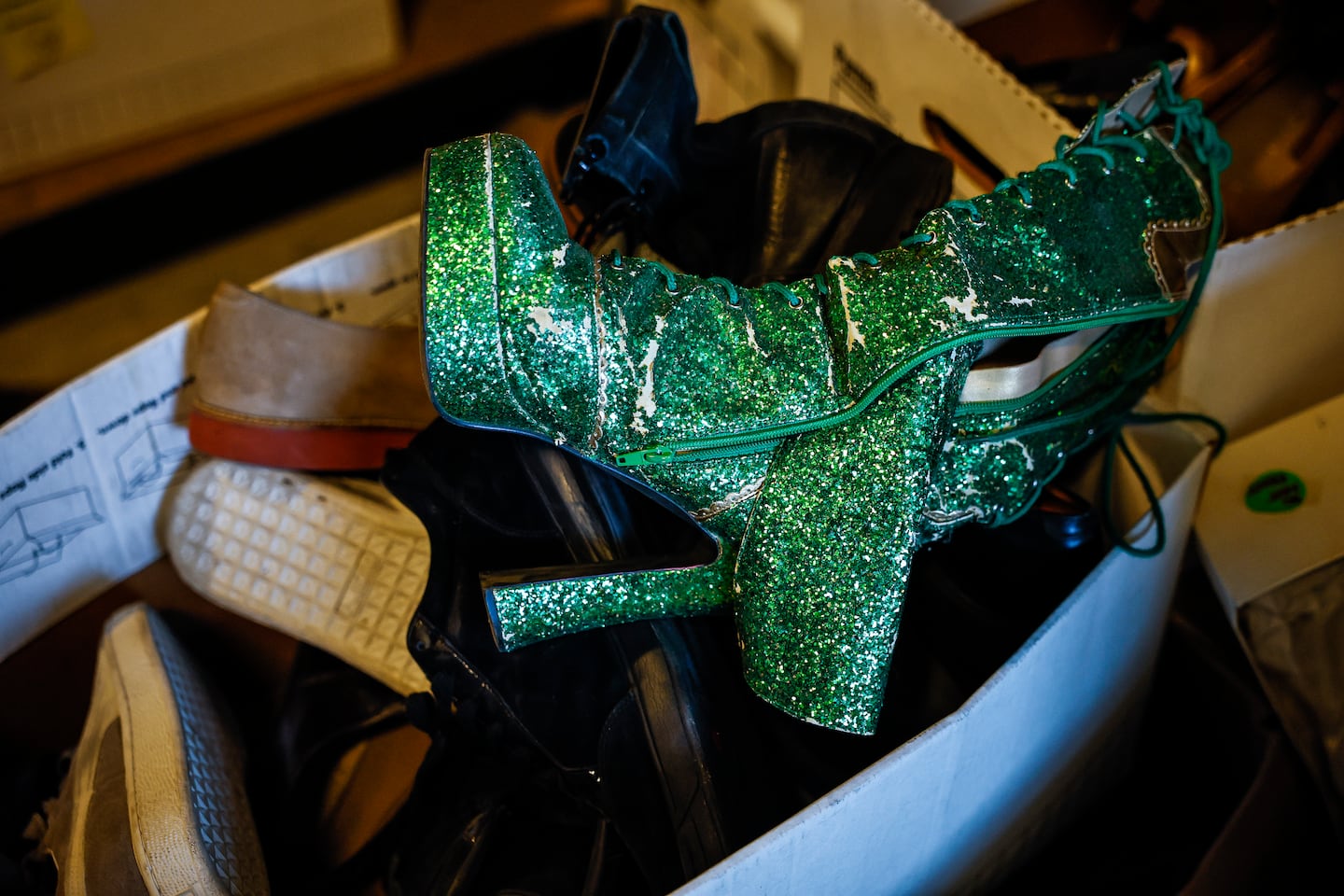 Costume pieces, including sparkly green boots, fill storage bins at the American Repertory Theater's costume shop sale in Cambridge.