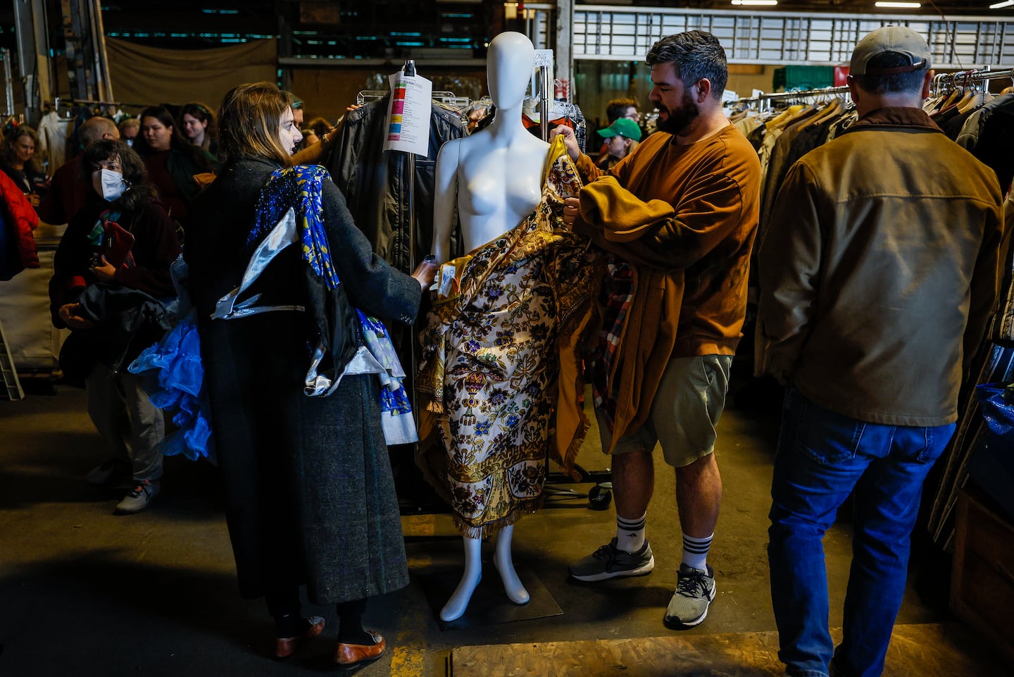 People undress a mannequin at the American Repertory Theater's costume shop sale in the week leading up to Halloween. 