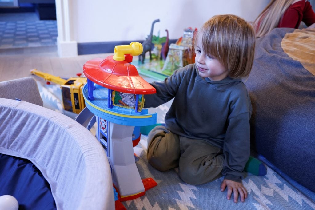 a small child plays with a colorful plastic toy