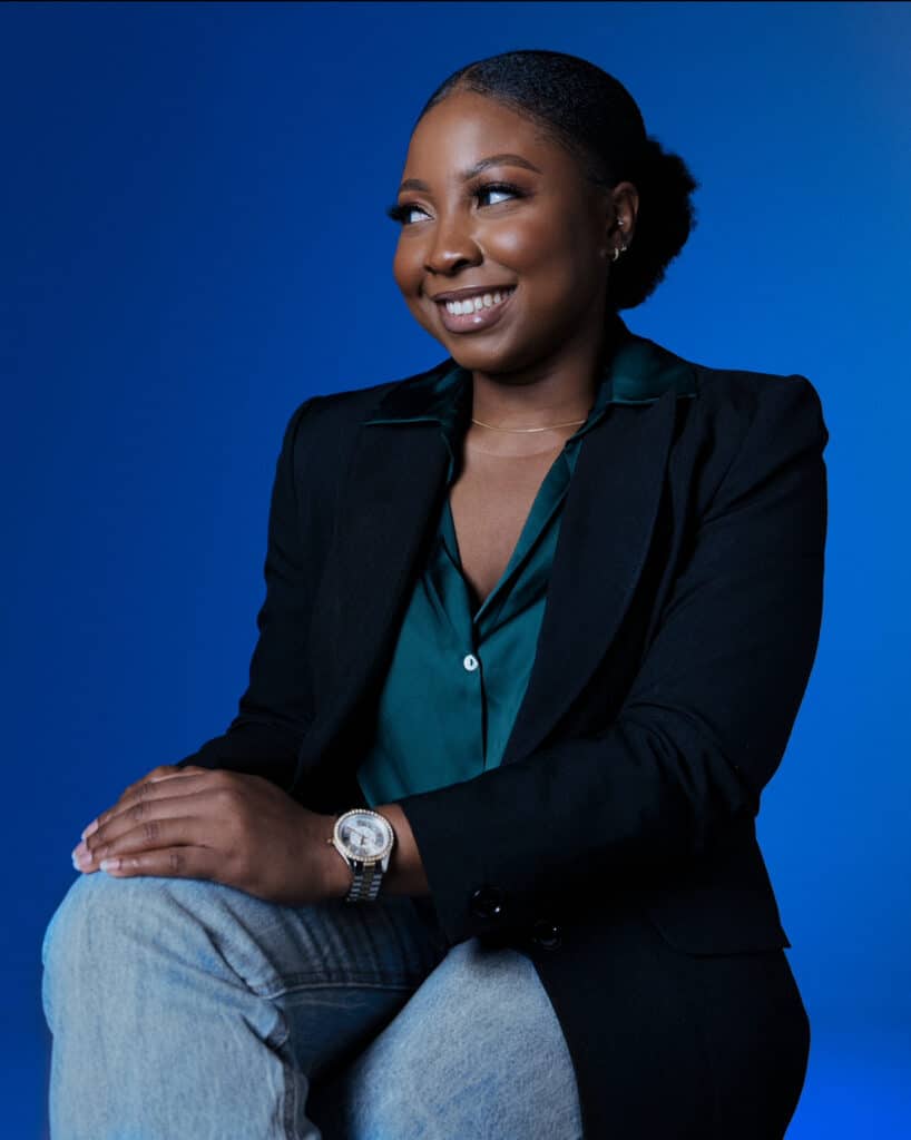 Nneka in a professional photo shoot, with a blue gradient background.