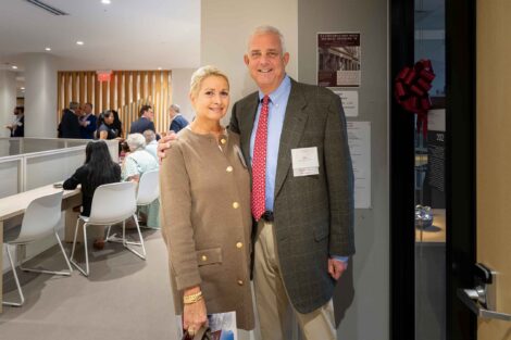 Tracy Hagert Sutka ’82, P’17, J. Michael Sutka ’83, P’17, and Christopher R. Sutka ’17 stand outside their named office in the Simon Center. Tracy is wearing a tan jacket.