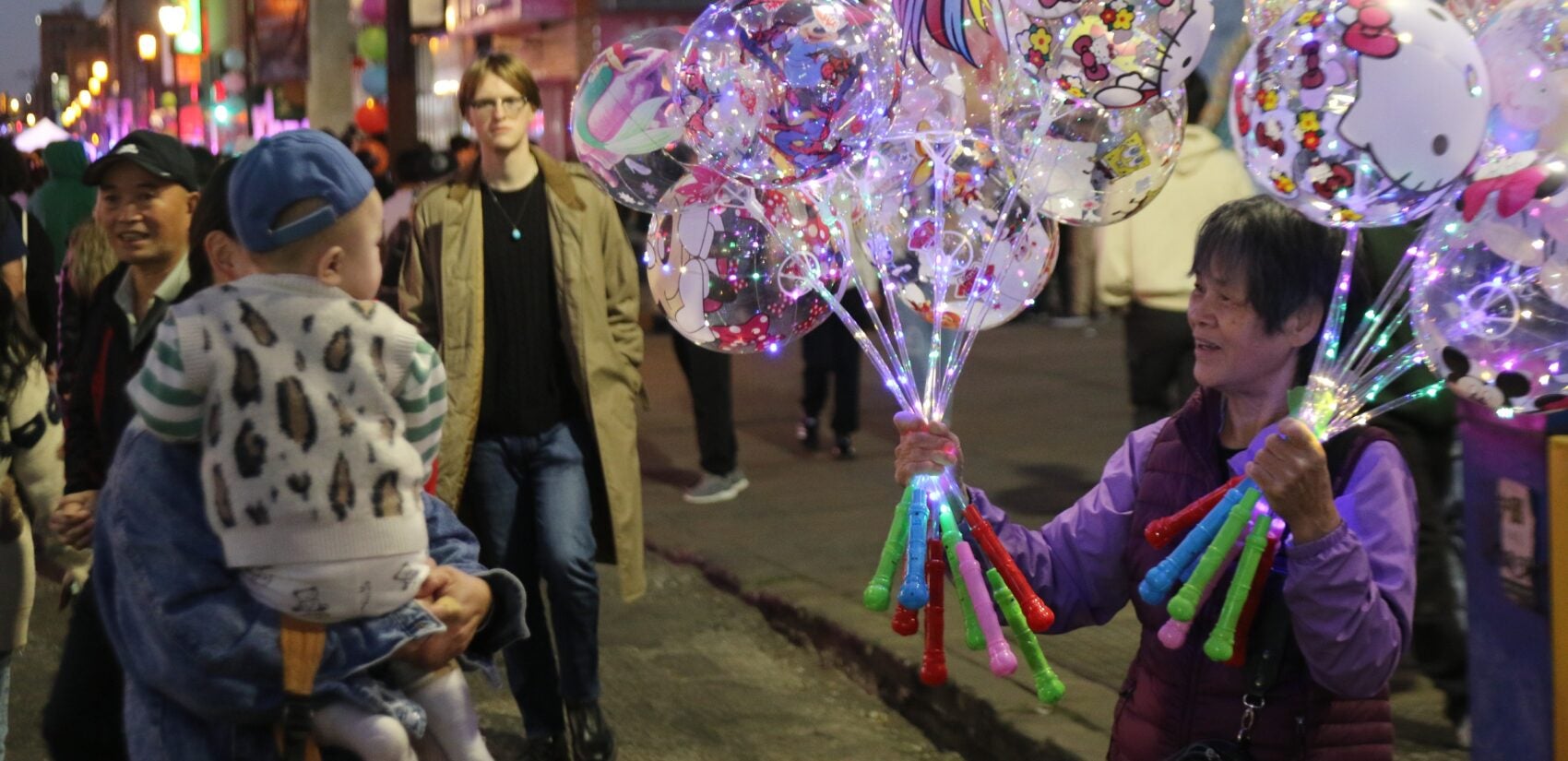 a person selling balloons to a kid