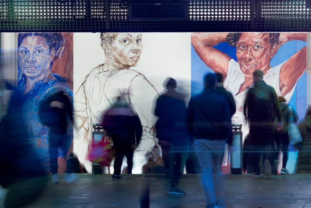 A mural of three women at a station in London