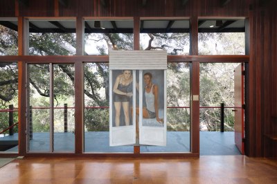 Few of a painting showing two people seen through an open Paris-style long window installed in a midcentury home. 