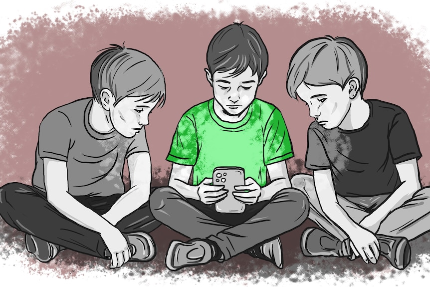 Three children sit on the ground looking at a mobile phone.