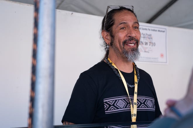 Pat Pruitt speaks to customers at his booth at the Santa Fe Indian Market on Aug. 17, 2024 in Santa Fe, New Mexico.