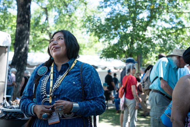 Naiomi Glasses speaks to customers and art applicators at her booth at the Santa Fe Indian Market on Aug. 17, 2024 in Santa Fe, New Mexico.