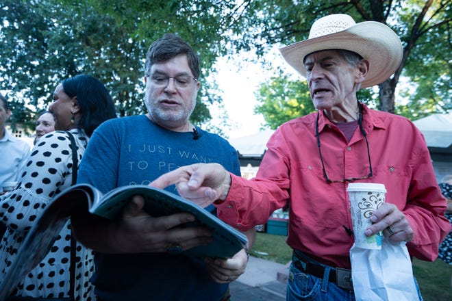 Fellow art collectors Ari Plosker (left) and Marc Applebaum look at a map of the Santa Fe Indian Market on Aug. 17, 2024 in Santa Fe, New Mexico.