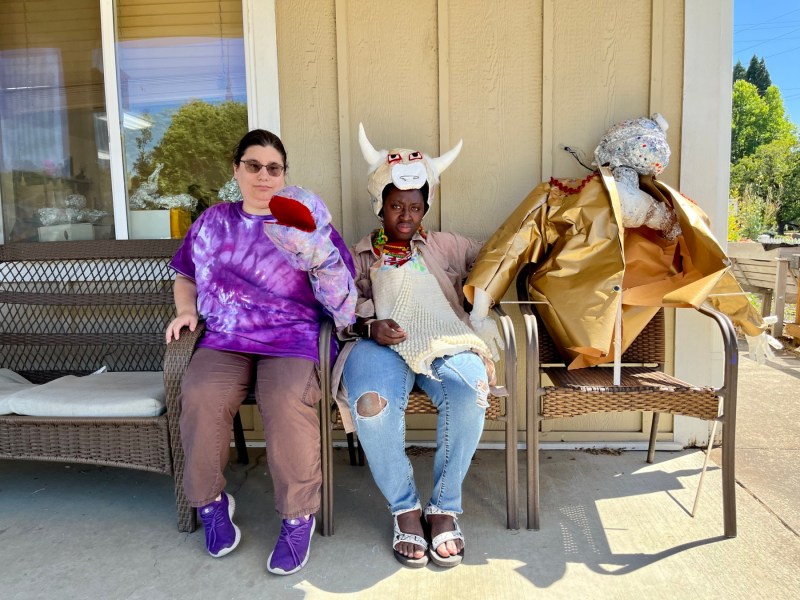 Two people on a bench with a sculpture