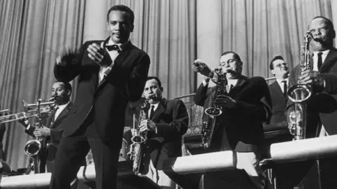 Getty Images Quincy Jones clapping and dancing in front of musicians in his big band in about 1960