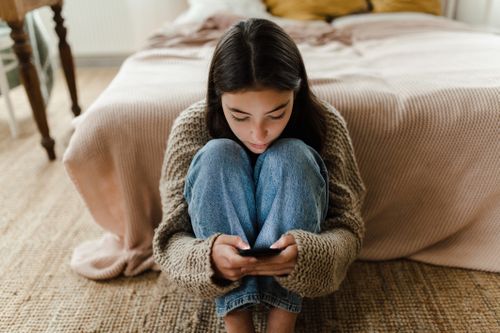 Stock photo of teenager using smartphone